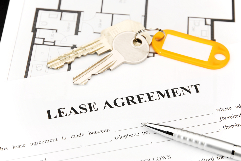 A lease agreement with keys on top of it.